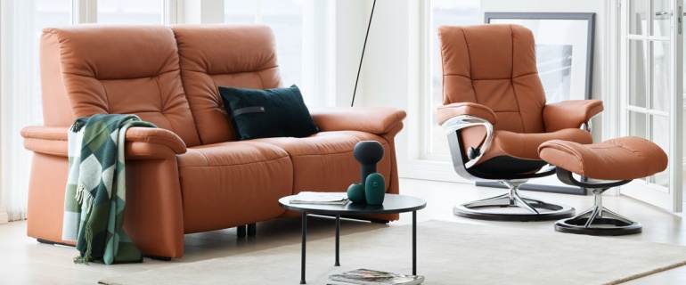 Brown leather sofa and recliner chair set in a bright modern living room